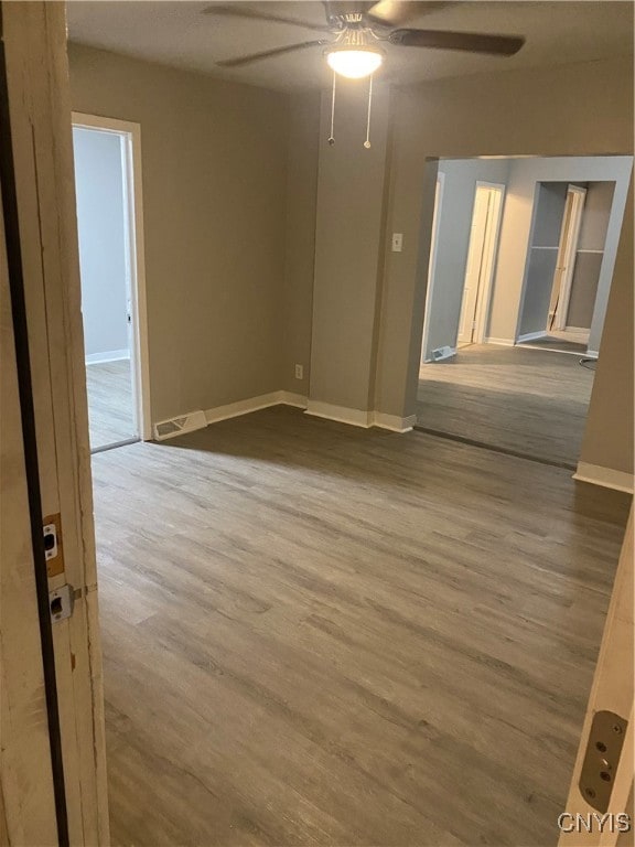 empty room featuring ceiling fan and hardwood / wood-style flooring