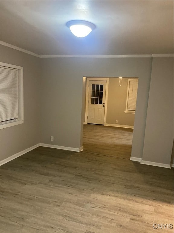 spare room with ornamental molding and hardwood / wood-style flooring