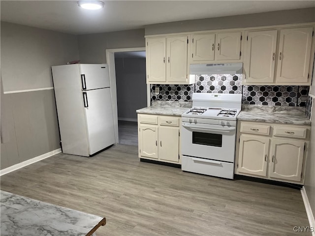 kitchen with light wood-type flooring, white appliances, and decorative backsplash