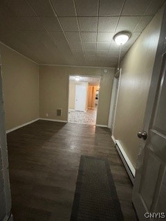 hall with dark wood-type flooring and a baseboard heating unit