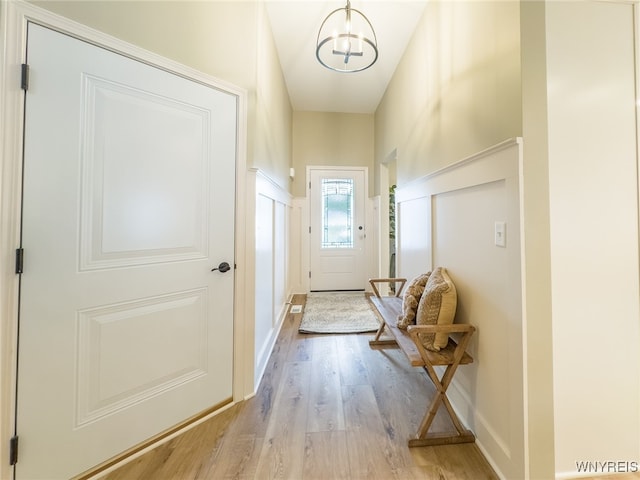 doorway to outside featuring light hardwood / wood-style floors and a notable chandelier