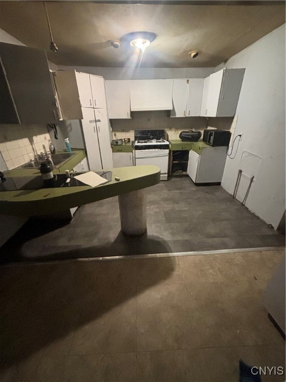 kitchen featuring white cabinets, white gas range, and decorative backsplash