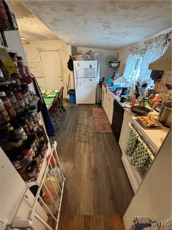 kitchen featuring white fridge, white cabinetry, sink, and dark hardwood / wood-style floors