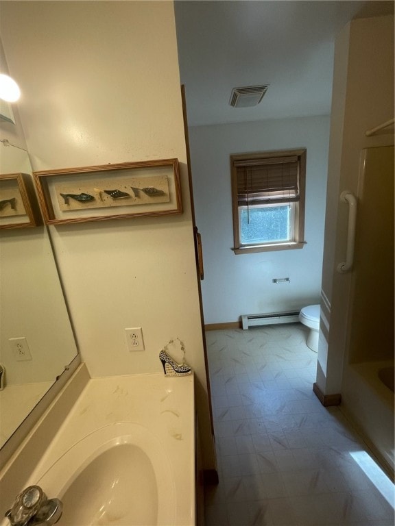 bathroom with a baseboard heating unit, toilet, a washtub, vanity, and tile patterned floors