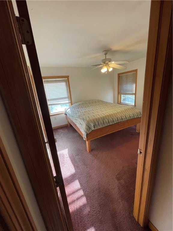 unfurnished bedroom featuring dark carpet and ceiling fan