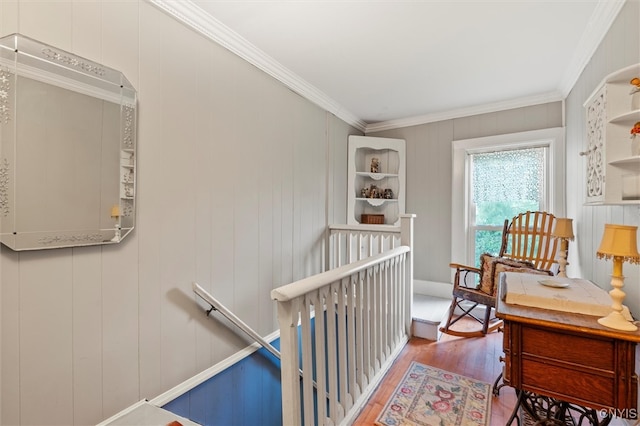 hallway featuring crown molding, hardwood / wood-style floors, and wooden walls