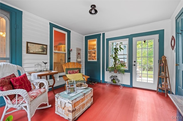 sitting room featuring hardwood / wood-style flooring and wooden walls