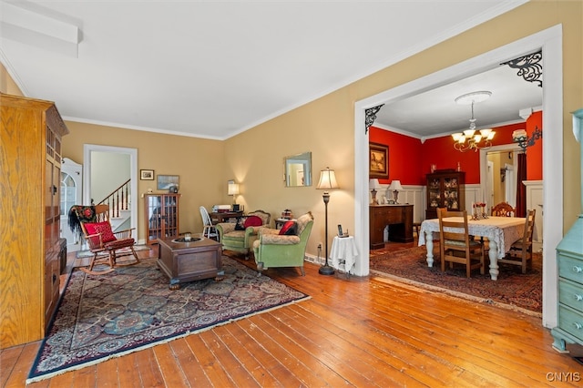 living room featuring crown molding, hardwood / wood-style floors, and an inviting chandelier