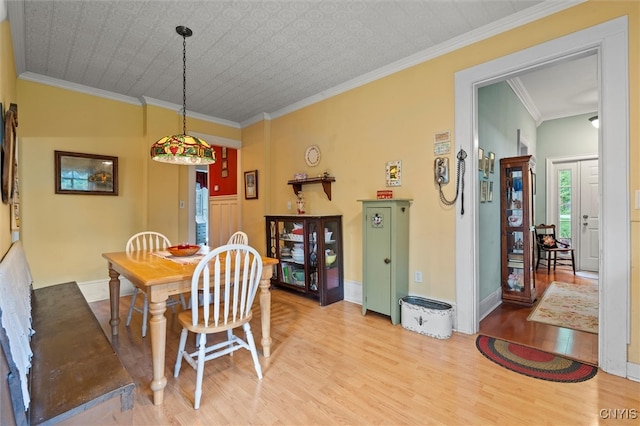 dining area featuring ornamental molding and light hardwood / wood-style floors