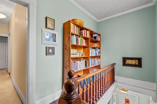 hall with ornamental molding and light carpet