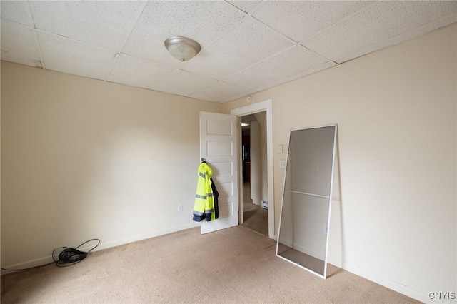 unfurnished bedroom featuring carpet flooring and a paneled ceiling