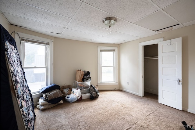 interior space featuring multiple windows, a closet, and a paneled ceiling