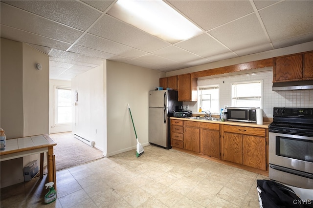 kitchen featuring a paneled ceiling, stainless steel appliances, tasteful backsplash, and a baseboard heating unit