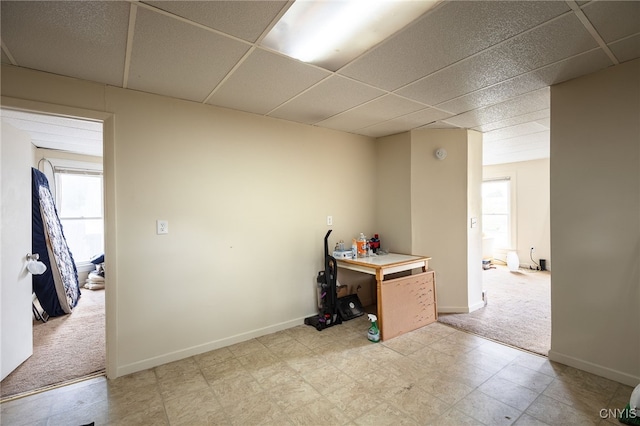 interior space featuring a drop ceiling and light colored carpet