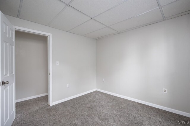 carpeted empty room featuring a paneled ceiling