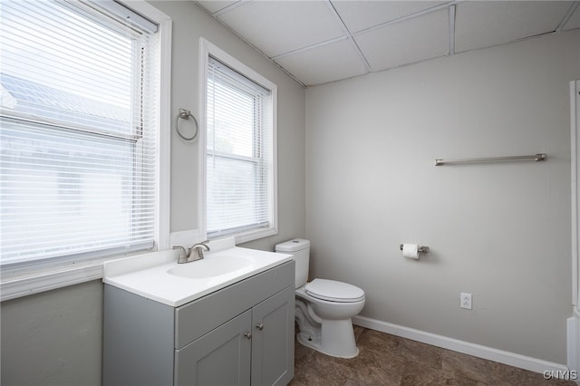 bathroom featuring toilet, a drop ceiling, and vanity