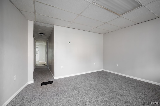 spare room featuring carpet floors and a paneled ceiling