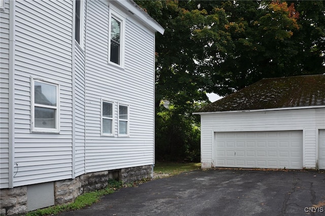 view of property exterior with an outdoor structure and a garage