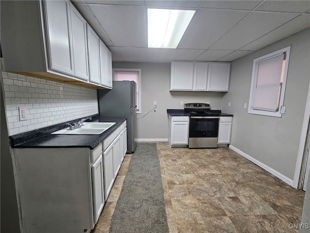 kitchen with stainless steel appliances, sink, white cabinetry, a paneled ceiling, and tasteful backsplash