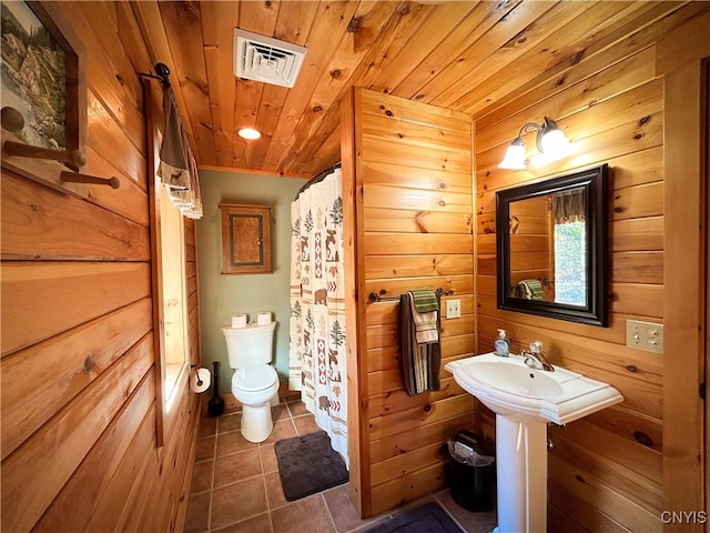 bathroom featuring walk in shower, wood ceiling, wooden walls, tile patterned flooring, and toilet