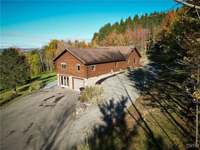 view of side of property featuring central AC unit and a garage