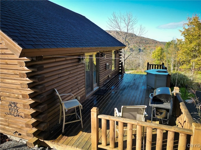 deck with grilling area and a mountain view