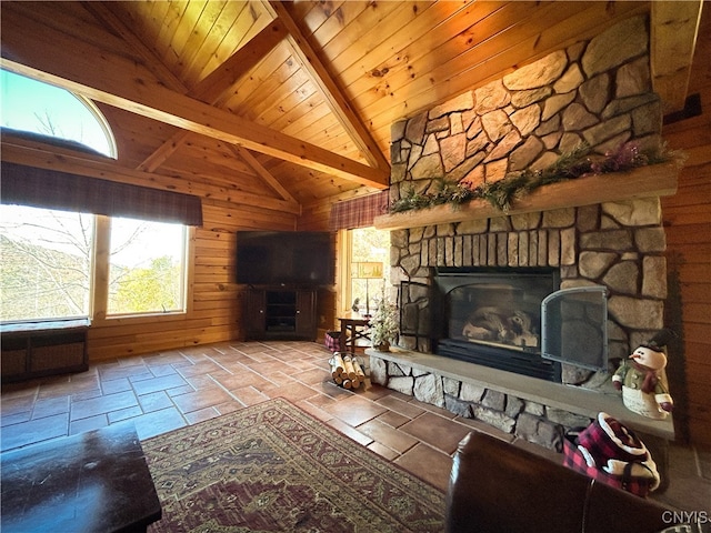 unfurnished living room with a stone fireplace, beam ceiling, high vaulted ceiling, wood walls, and wood ceiling