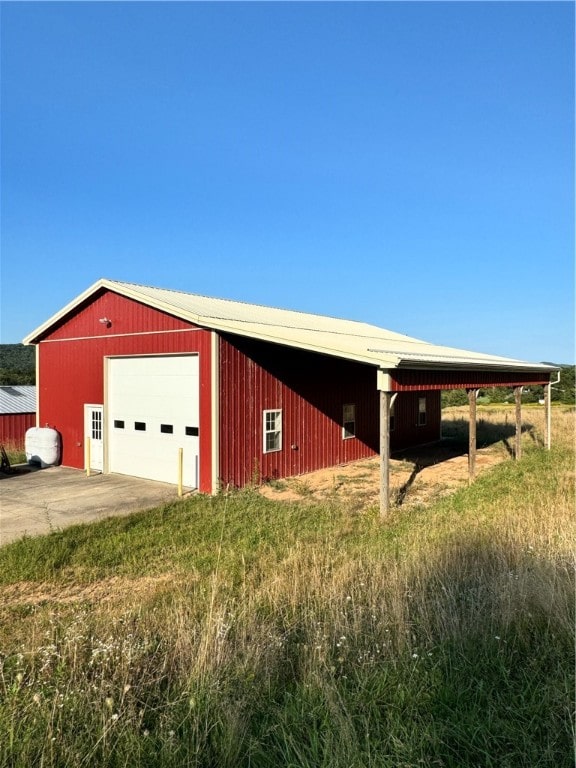 view of outdoor structure with a carport and a garage