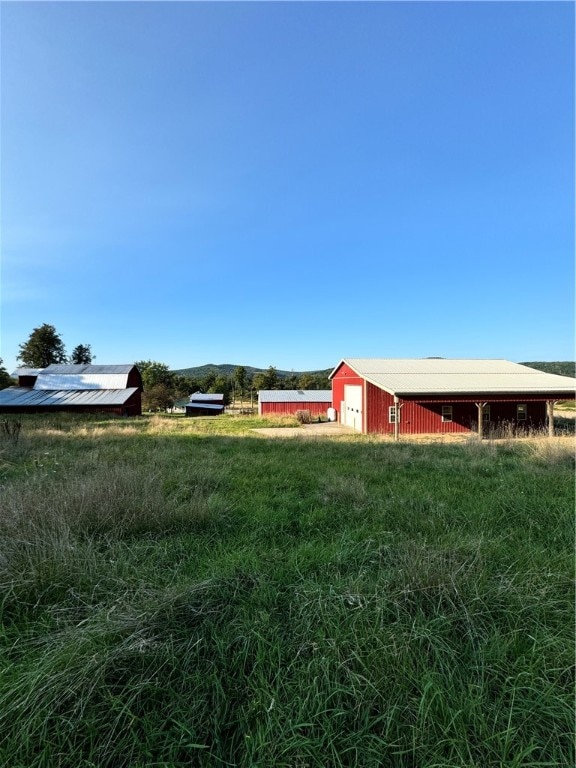 view of yard with a rural view and an outbuilding