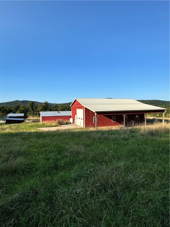 view of outdoor structure with a mountain view and a rural view