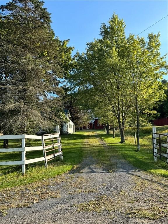 view of gate featuring a lawn and a rural view