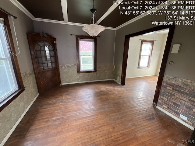 unfurnished dining area with hardwood / wood-style flooring, a healthy amount of sunlight, and crown molding