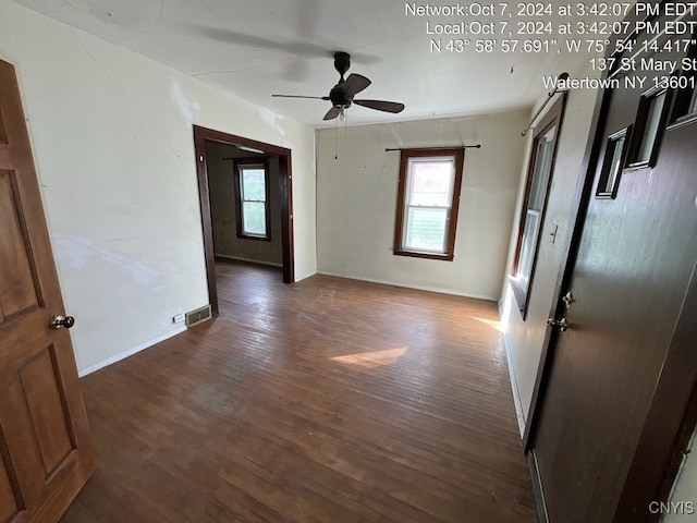 empty room with ceiling fan and dark hardwood / wood-style floors