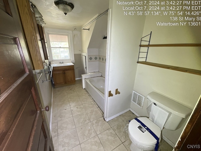 bathroom with vanity, a tub to relax in, tile patterned flooring, and toilet