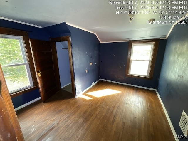 unfurnished room with hardwood / wood-style flooring and lofted ceiling