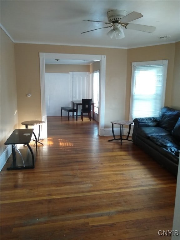 living room with ornamental molding, ceiling fan, and dark hardwood / wood-style flooring