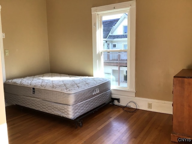 bedroom featuring dark hardwood / wood-style flooring and multiple windows