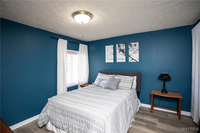 bedroom featuring wood-type flooring and a textured ceiling