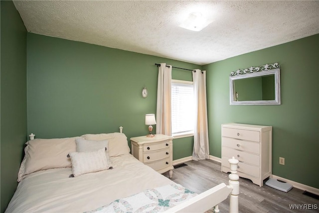 bedroom featuring hardwood / wood-style floors and a textured ceiling