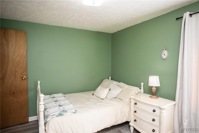 bedroom featuring dark hardwood / wood-style flooring and a textured ceiling