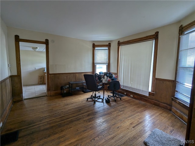 office area featuring wooden walls and hardwood / wood-style floors