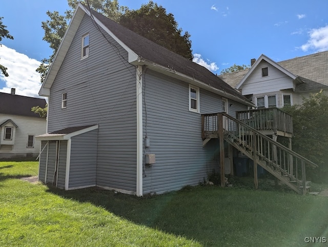 view of home's exterior featuring a wooden deck and a lawn