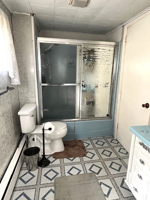 full bathroom with vanity, ornamental molding, combined bath / shower with glass door, a baseboard radiator, and toilet