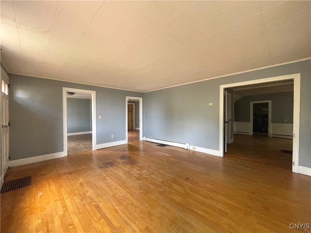 unfurnished room with hardwood / wood-style floors, crown molding, and a baseboard radiator