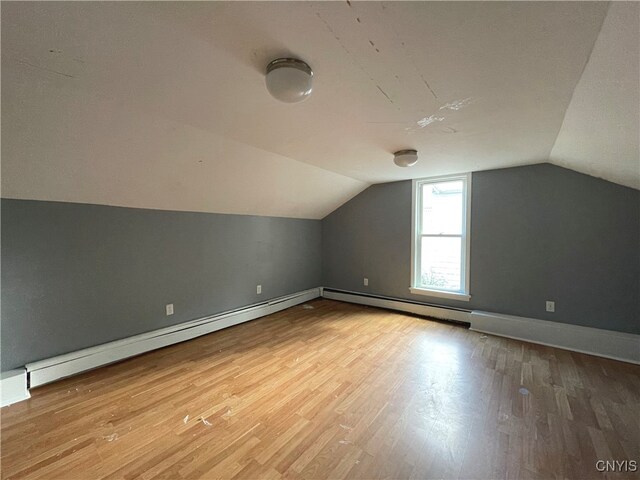 bonus room with hardwood / wood-style flooring, baseboard heating, and vaulted ceiling