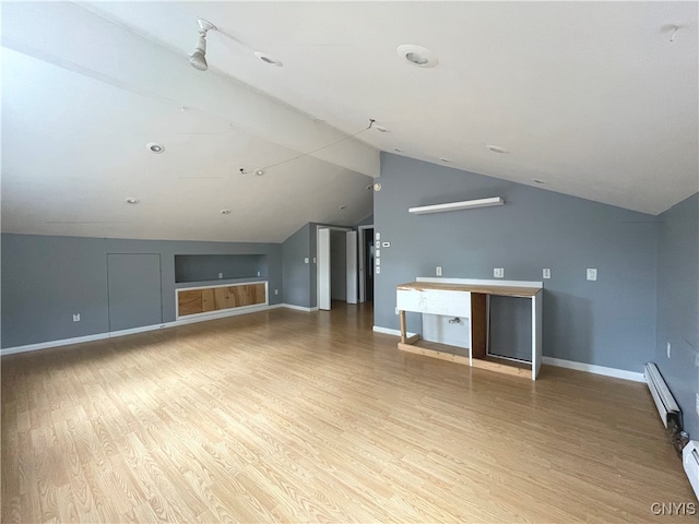 unfurnished living room with wood-type flooring, a baseboard radiator, and vaulted ceiling