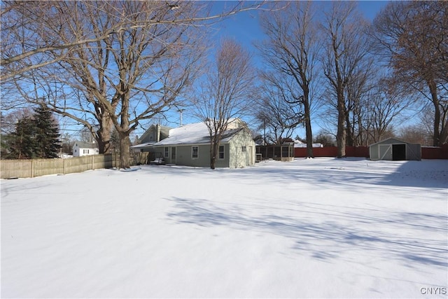 snowy yard featuring an outdoor structure