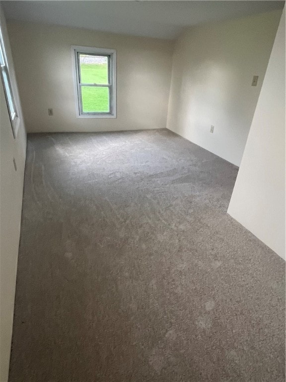 unfurnished room featuring dark colored carpet