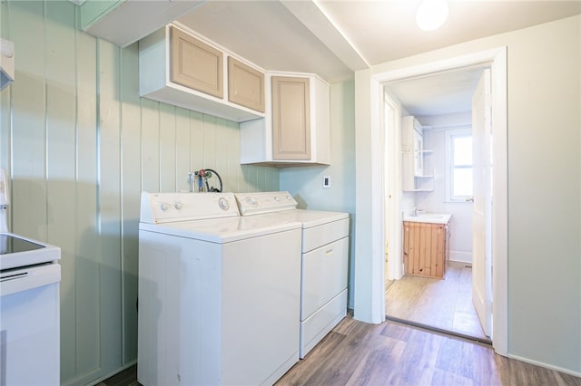 laundry area with washing machine and dryer and light wood-type flooring