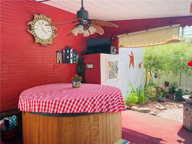 view of patio / terrace with ceiling fan and a hot tub